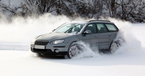 An image showing a car driving in the snow.