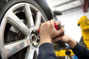 An image showing a mechanic putting new tires on a car.