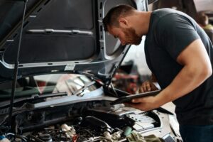 Mechanic diagnosing a vehicle problem during an auto repair inspection in Nashua, NH